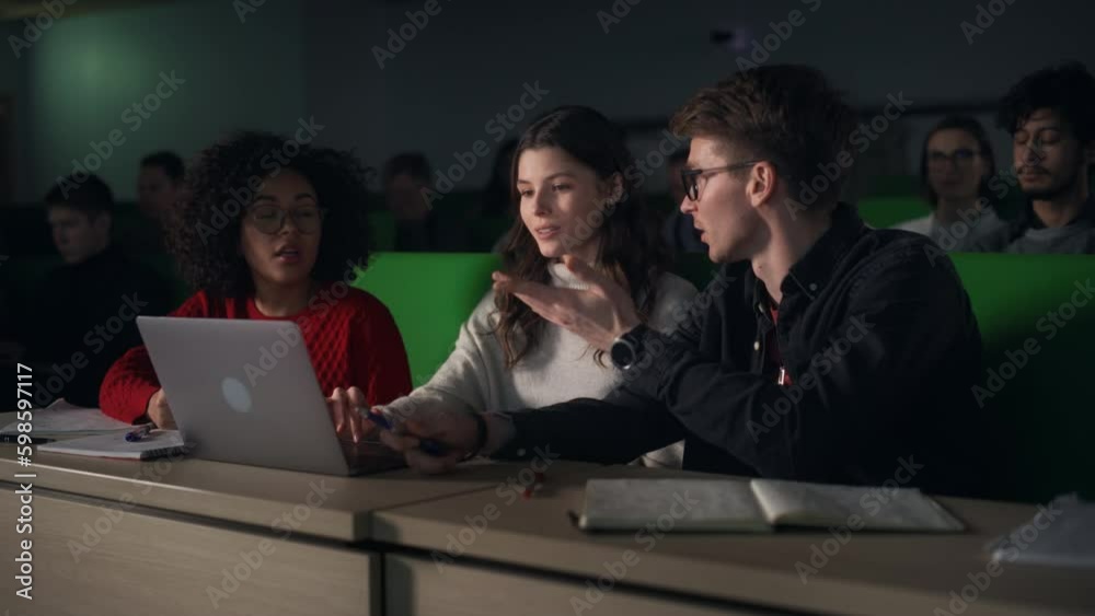 Poster Team of Enthusiastic Students Collaborate in University Classroom, Compare Research Project Work on a Laptop Computer. Diverse Scholars Working as a Group on College Homework