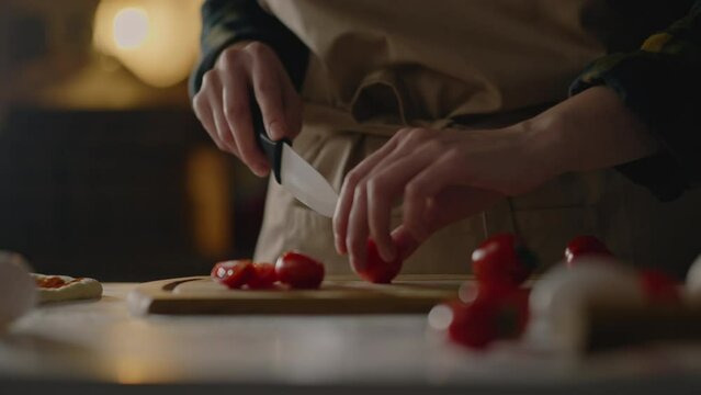 A professional chef cuts red tomatoes tomato for cooking an author's dish, Cutting ingredients tomato for cooking pizza margherita Neapolitan Italian red tomato and cheese pizza

