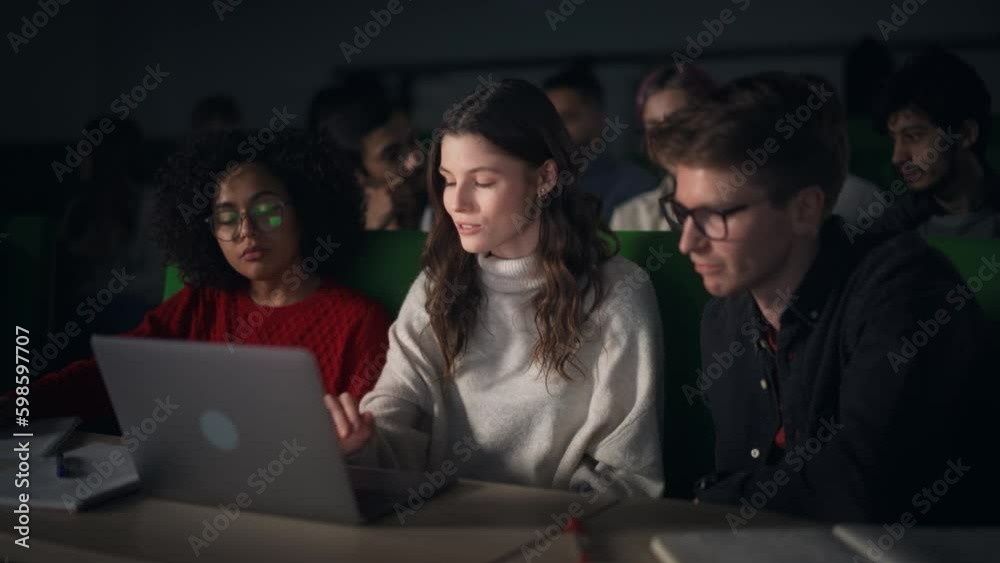Poster Group of Diverse Happy Students Having a Conversation in University Classroom, Working on a Shared Research Project on a Laptop Computer. Classmates Working Together on College Homework
