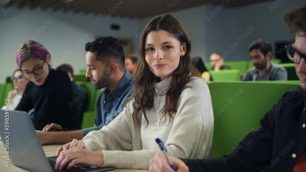 Poster Beautiful Smart Female Student Studying in University with Diverse Multiethnic Classmates. Portrait of a Happy Caucasian Female Looking at Camera and Smiling. She is Using a Laptop Computer
