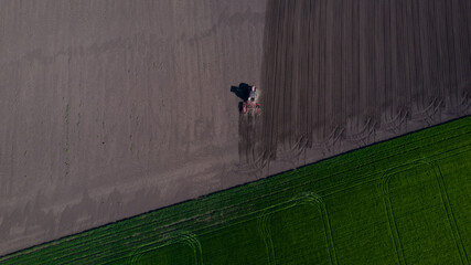 Aerial  view of tractor on sowing field.Sowing the crop in the agricultural field. Barley, corn, sunflower, wheat, oats.