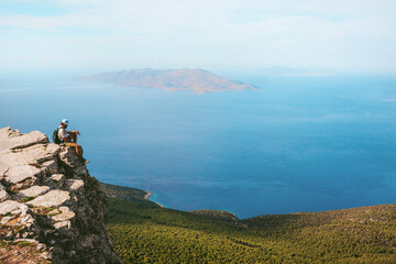 Man traveling in Greece sitting on cliff mountain alone active hiking vacations outdoor backpacker...