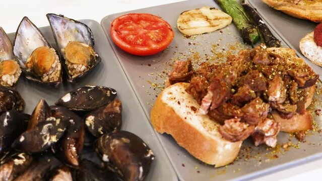 Turkish style appetizer street food stuffed mussels called midye dolma with lemon , Turkish kokorec and sucuk. High quality 4k footage Generative AI
