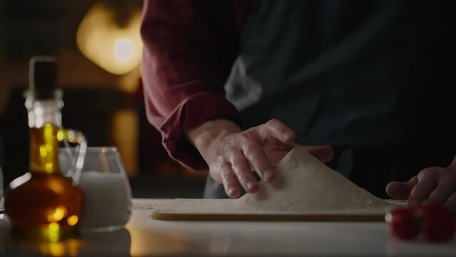Baking, Professional baker Sifting flour with a sieve in the bakery room touching the flour with his hand. Professional assistant cook Preparing the dough for baking Checking the poutine with his hand