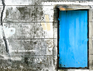 Blue door on old grunge concrete wall background