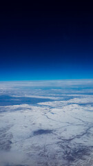 The Blue Earth from Above During Flight from Airplane Window View