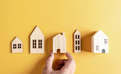 Increased value of real estate or property house. hand holding house wooden model investment...