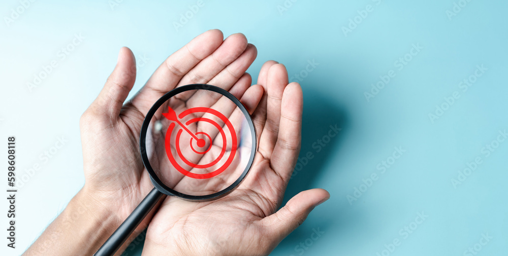 Aufkleber business hands holding target icon on magnifier, dartboard and arrow for creative and set up busines