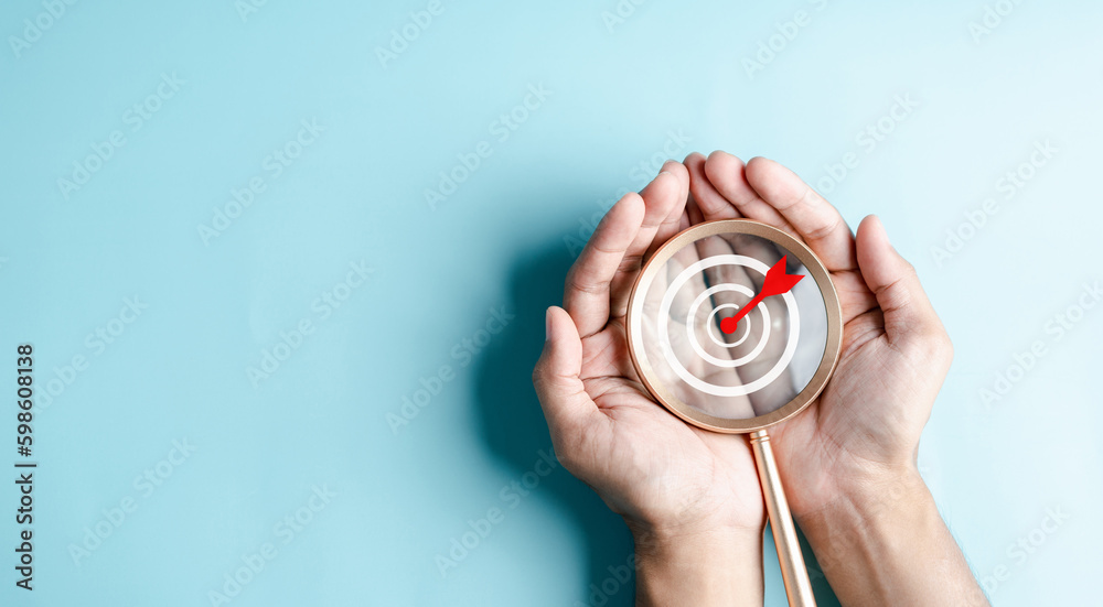 Aufkleber business hands holding target icon on magnifier, dartboard and arrow for creative and set up busines
