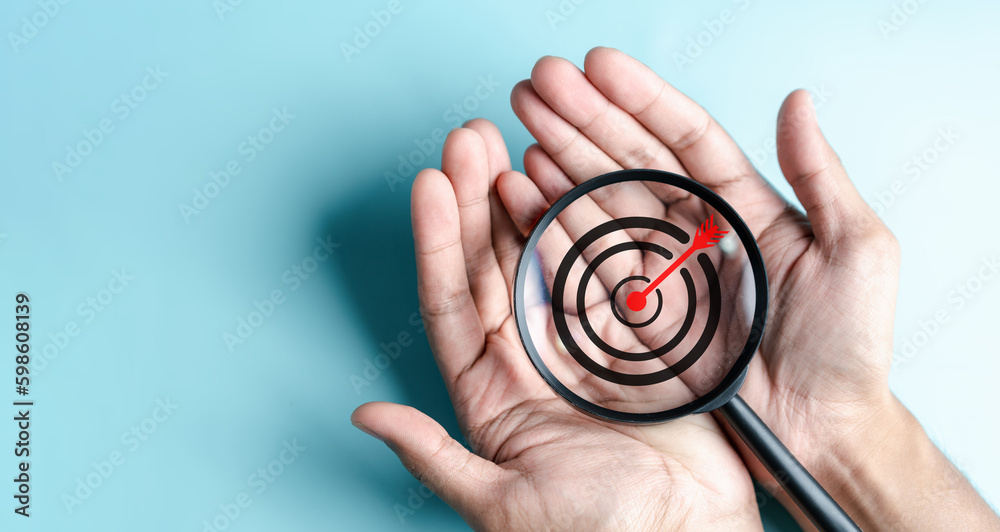 Aufkleber business hands holding target icon on magnifier, dartboard and arrow for creative and set up busines