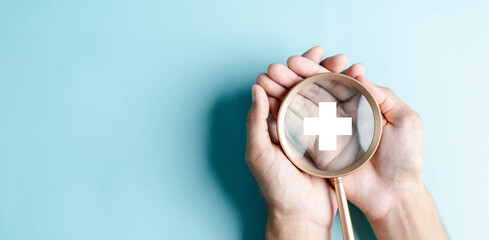 Fototapeta premium Health insurance healthcare medical concept. Hand people holding Magnifier focus to plus symbol icon, health and access to welfare health concept.