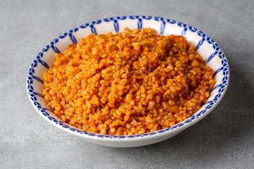 Traditional turkish bulgur pilaf with tomato sause in plate (Turkish name; meyhane pilavi or domatesli bulgur pilavi)