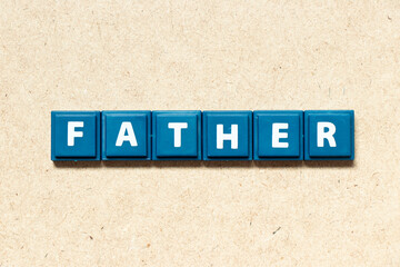 Tile alphabet letter in word father on wood background