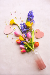Colorful spring flowers and pink hearts for mother's day. Vertical background for greeting card and banner. Top view with space for text.