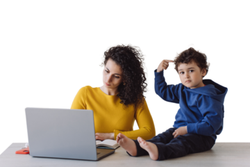 Italian young woman in yellow sweater sitting at table remote working with curly son sitting on table pointing on head knows that mom is clever against transparent background. Boy waiting for mom
