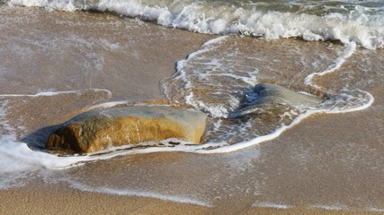 Sea waves crashing into sand