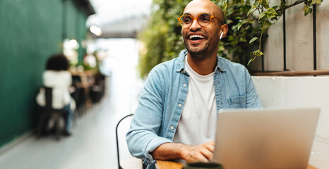 Professional man using a laptop to work from a coworking space