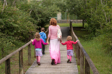 children with their mother walking through the park