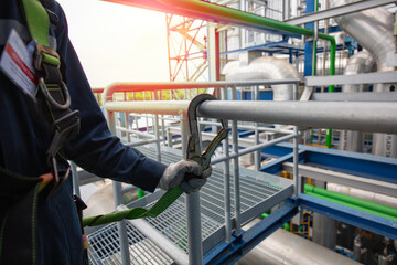 Male worker wearing safety harness hook working at high place