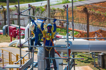 Fototapeta na wymiar Architect on site construction workers on a scaffold pipeline