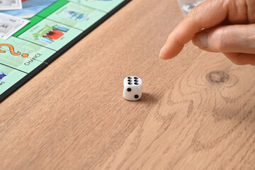 finger showing a dice in a board game