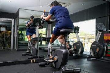 Portrait of disabled athlete woman with prosthetic leg in fitness gym