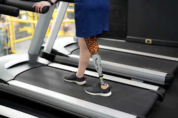 Portrait of disabled athlete woman with prosthetic leg in fitness gym