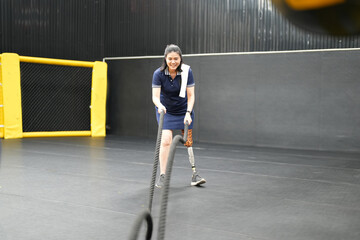 Portrait of disabled athlete woman with prosthetic leg in fitness gym