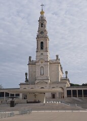 Fototapeta na wymiar Fatima, Portugal - March 29, 2023: The Sanctuary of Fatima (or Sanctuary of Our Lady of the Rosary of Fatima) is a Marian shrine dedicated to Our Lady of Fatima. Sunny spring day. Selective focus