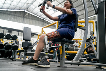 Fototapeta na wymiar Portrait of disabled athlete woman with prosthetic leg in fitness gym