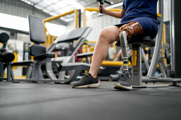 Fototapeta na wymiar Portrait of disabled athlete woman with prosthetic leg in fitness gym
