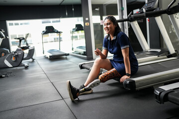Portrait of disabled athlete woman with prosthetic leg in fitness gym
