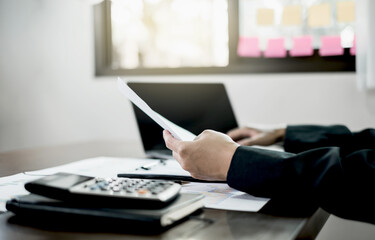 The businessman hand sits at their desks and calculates financial graphs showing the results of their investments planning the process of successful business growth