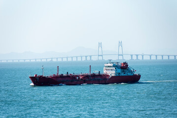 Cargo ship sailing near the Hong Kong Zhuhai Macau (Macao) Bridge, Chinese sea coast.