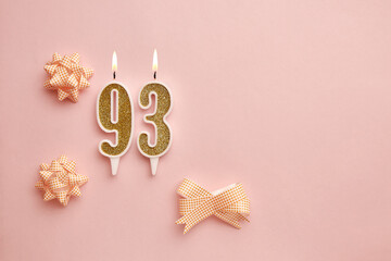 Candles with the number 93 on a pastel pink background with festive decor. Happy birthday candles. The concept of celebrating a birthday, anniversary, important date, holiday. Copy space. banner - obrazy, fototapety, plakaty