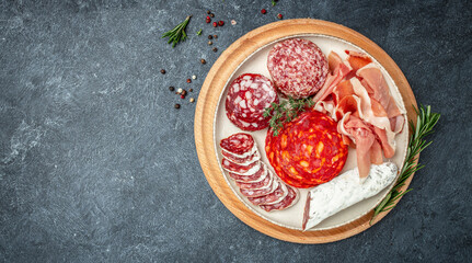 delicious salami, pieces of sliced prosciutto crudo, sausage and wine. Meat platter. Mixed delicatessen of meat snacks. place for text, top view