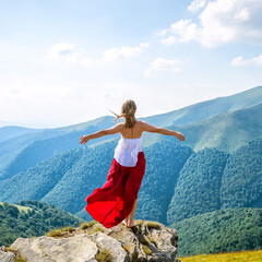 Young woman on the top of mountain