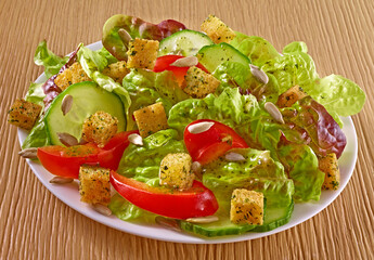 Frischer Salat mit Croutons und Tomaten dazu Grukenscheiben und Sonnenblumenkerne