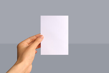 Realistic hand holding A6 paper mockup. Portrait A6 international paper size mockup. Simple, clean, modern, minimal paper mock up. Paper mockup in hand © Vinh