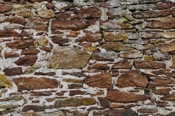 Old masonry made of red natural stone