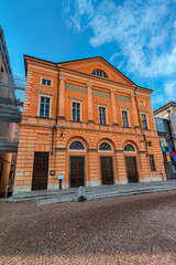 Facade of the orange historic building in Alba, Italy.