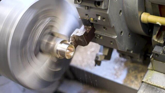 Automated CNC machine processes brass workpiece. Making a bronze bushing. Industrial production video