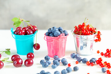 Mix of fresh berries in small buckets.