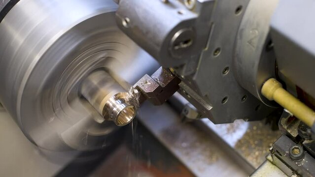 Automated CNC machine processes brass workpiece. Making a bronze bushing. Industrial production video