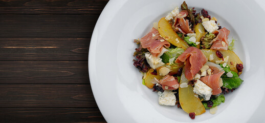 gourmet salad with pear, ham, cheese and nuts
