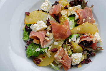 gourmet salad with pear, ham, cheese and nuts