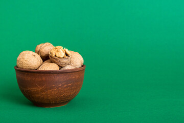 Fresh healthy walnuts in bowl on colored table background. Top view Healthy eating bertholletia concept. Super foods