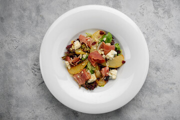 gourmet salad with pear, ham, cheese and nuts