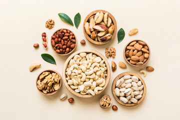 Fototapeta na wymiar mixed nuts in wooden bowl. Mix of various nuts on colored background. pistachios, cashews, walnuts, hazelnuts, peanuts and brazil nuts