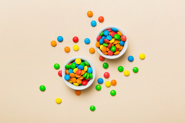 different colored round candy in bowl and jars. Top view of large variety sweets and candies with copy space